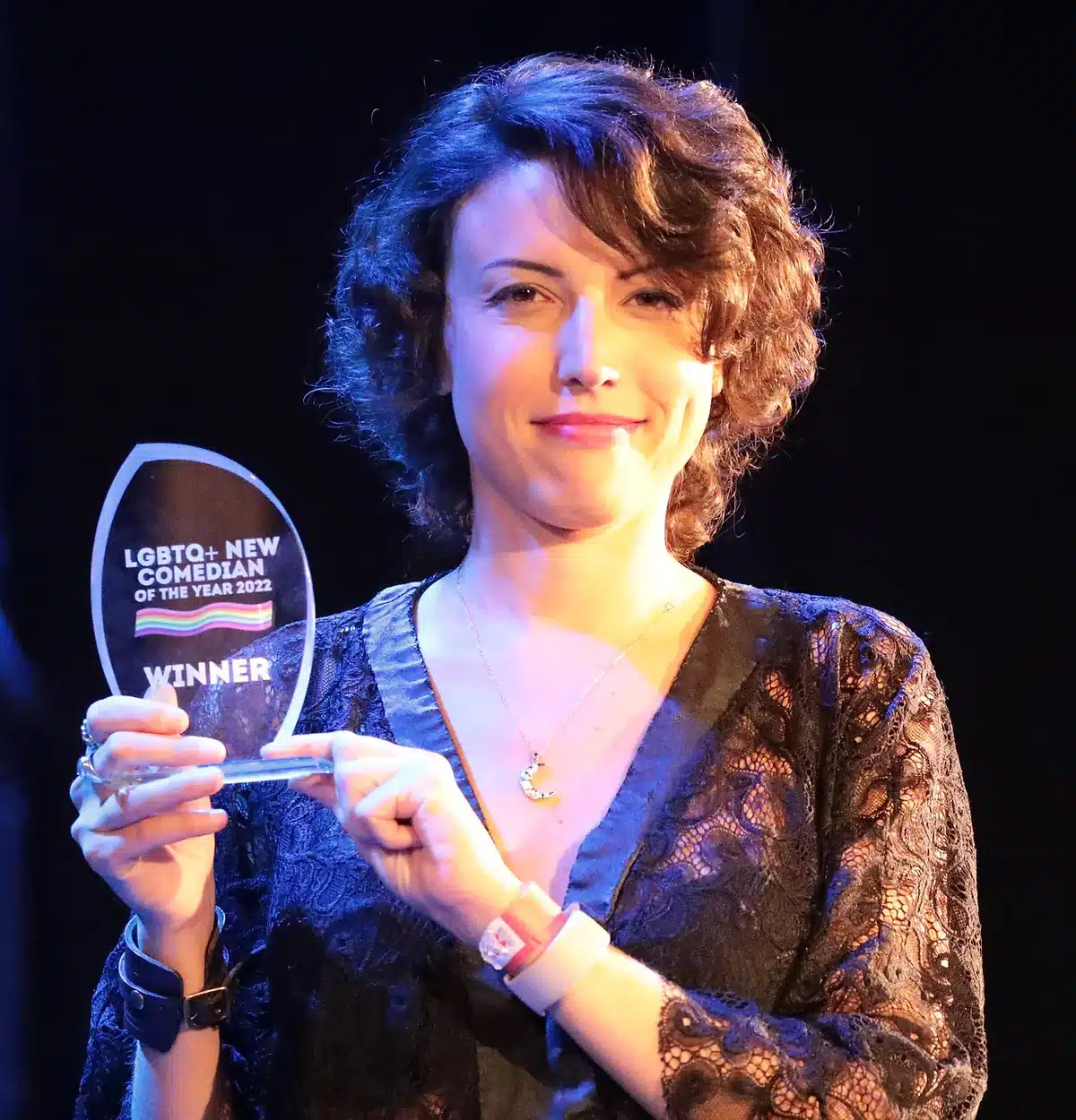 Victoria Olsina holding her LGBTQ+ New Comedian of the Year 2022 award